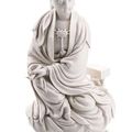 A fine 'blanc de chine' model of guanyin seated on a rock with a book, china, impressed mark he chaozong and xuande, 17th ct. 