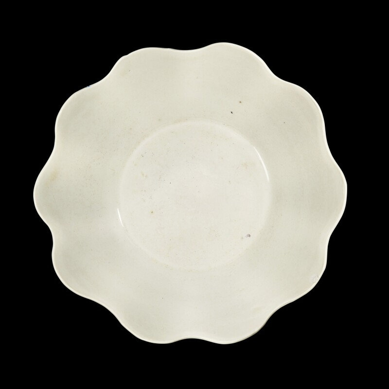 A Dingyao white-glazed foliate-rim bowl with an inscribed 'guan' mark Five dynasties