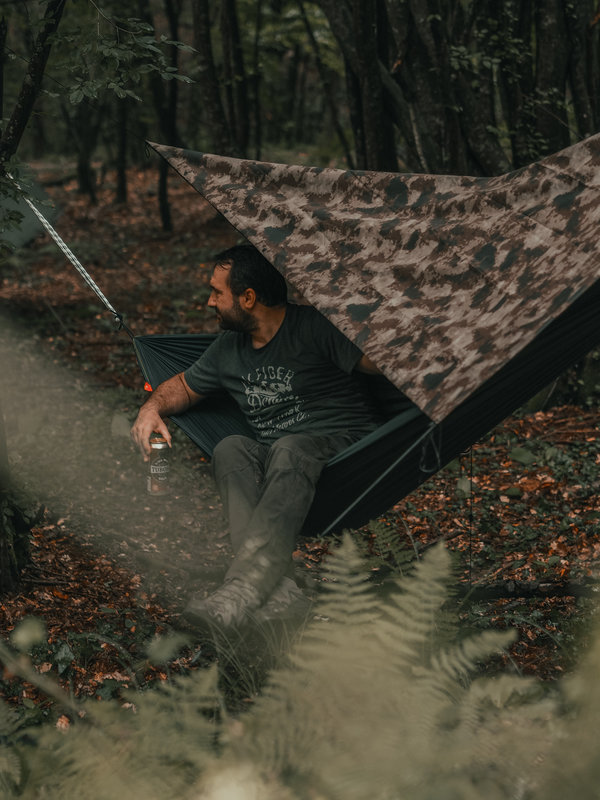 Un homme sur un hamac en forêt