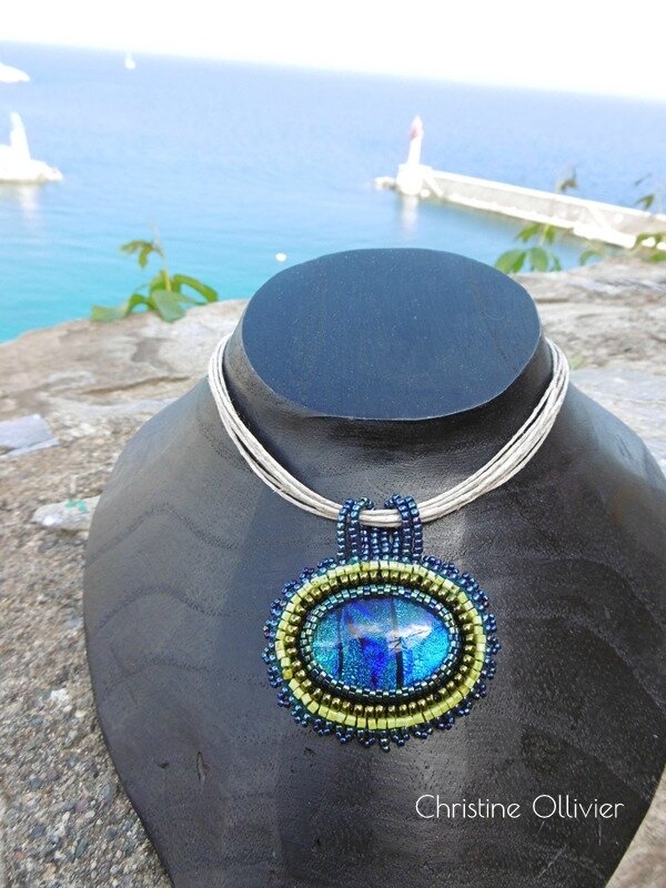 Pendentif avec un cabochon dichroïque couleur bleu sur cordon en lin.